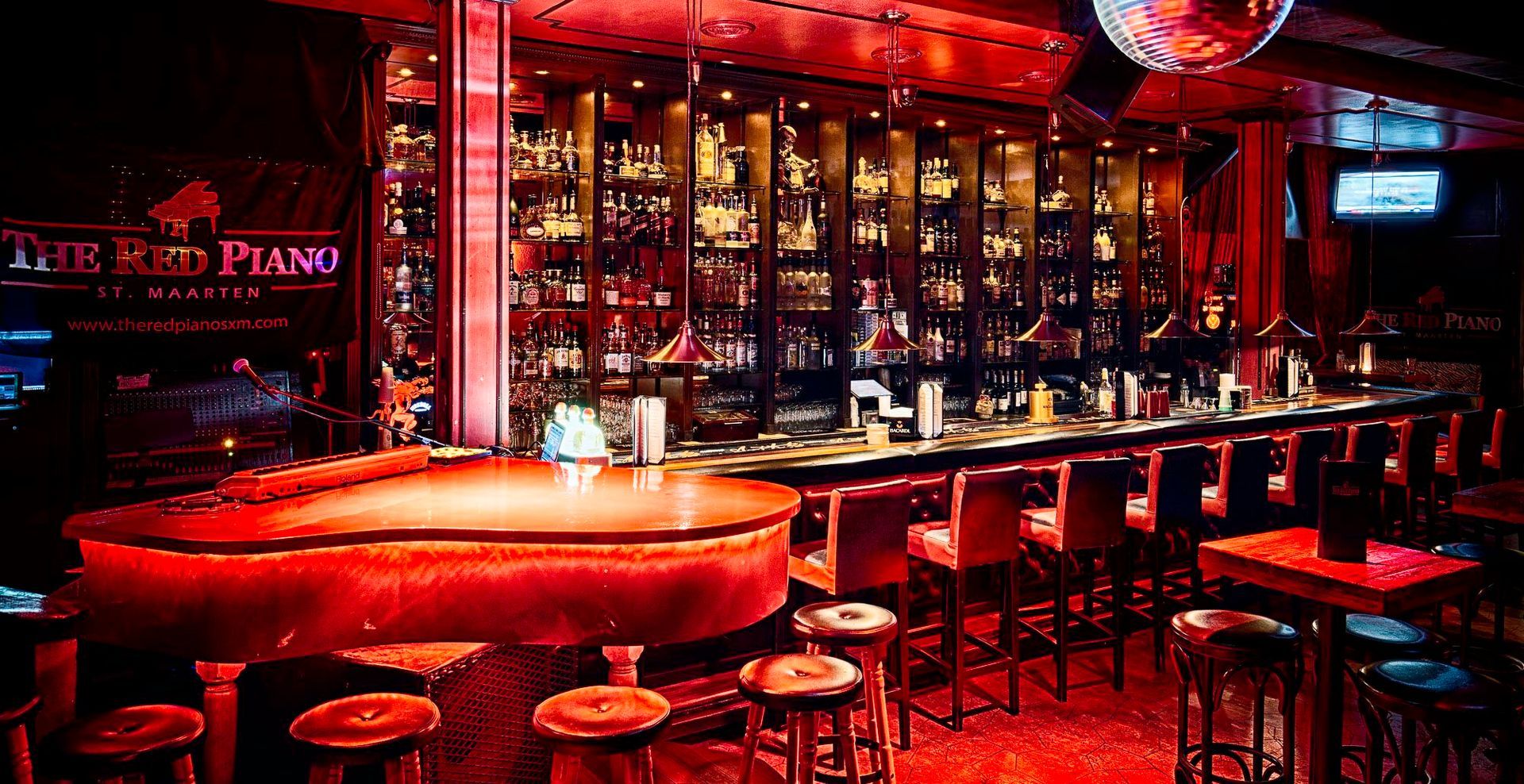 A bar with a red piano and a sign that says the red piano