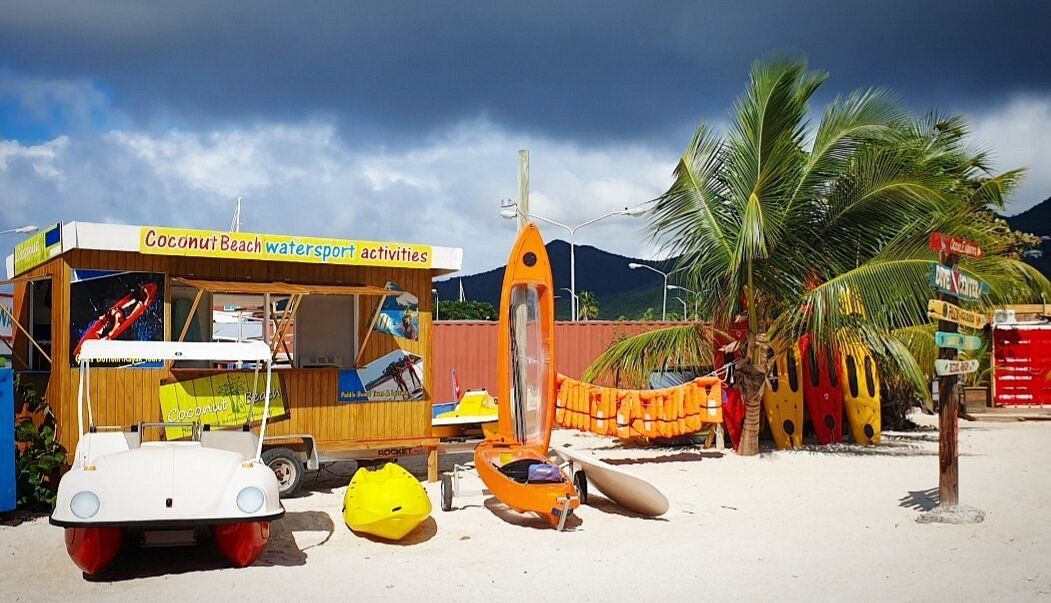 A beach with a bunch of boats and a kiosk.