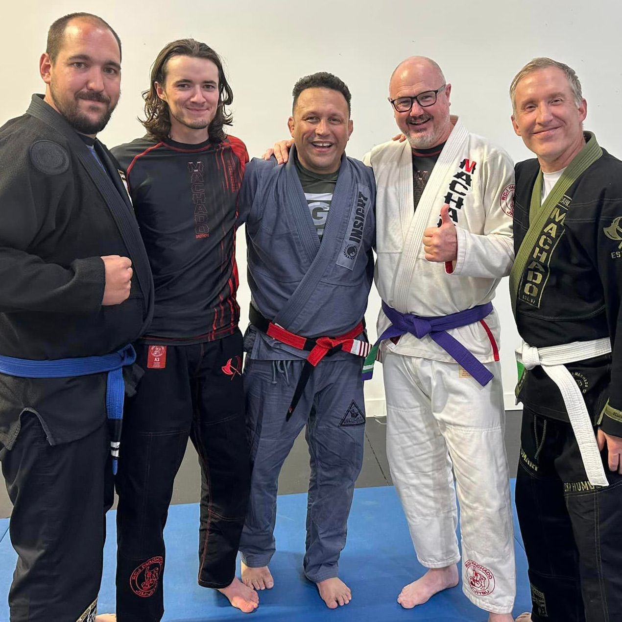 A group of men in karate uniforms are posing for a picture