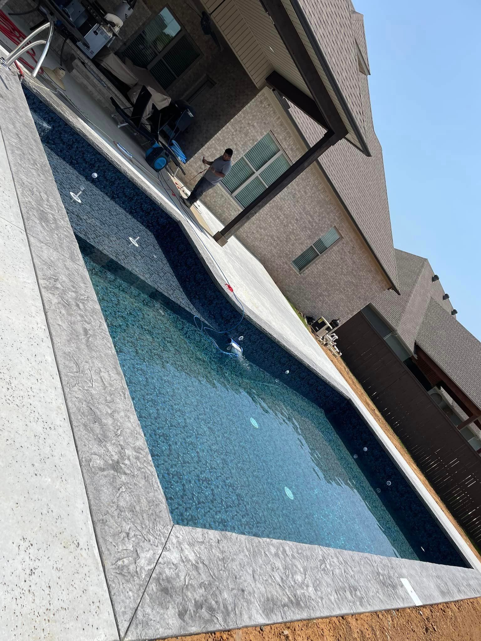 A large swimming pool in the backyard of a house.