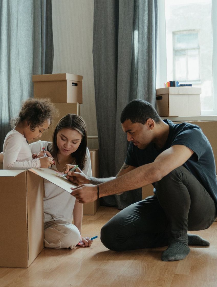 A family is moving into a new home and playing with cardboard boxes.