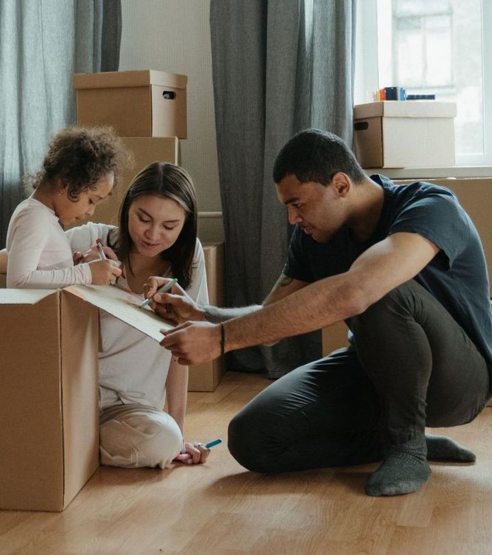 A man and a woman are kneeling on the floor with a child.