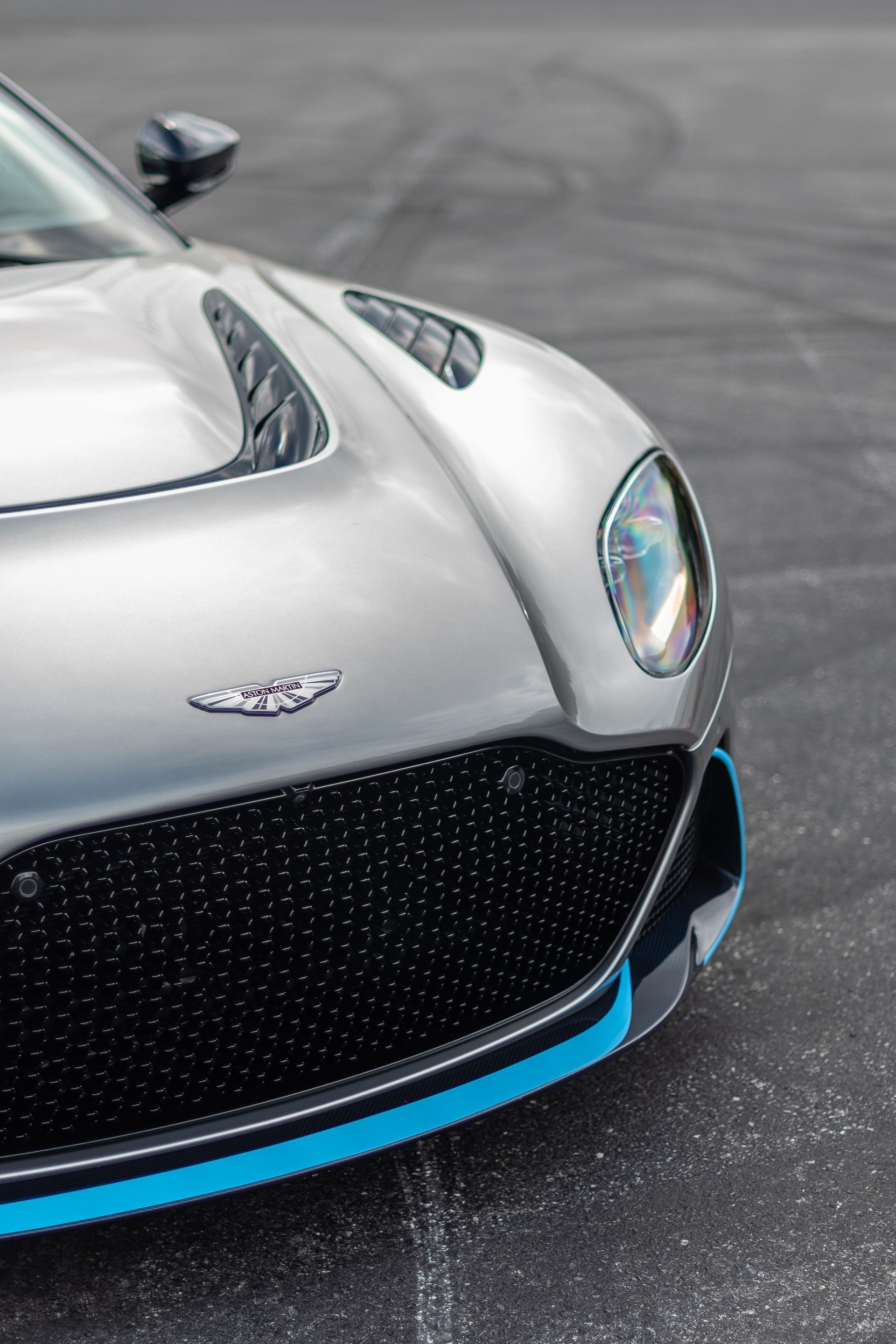 A silver and black sports car is parked in a parking lot.
