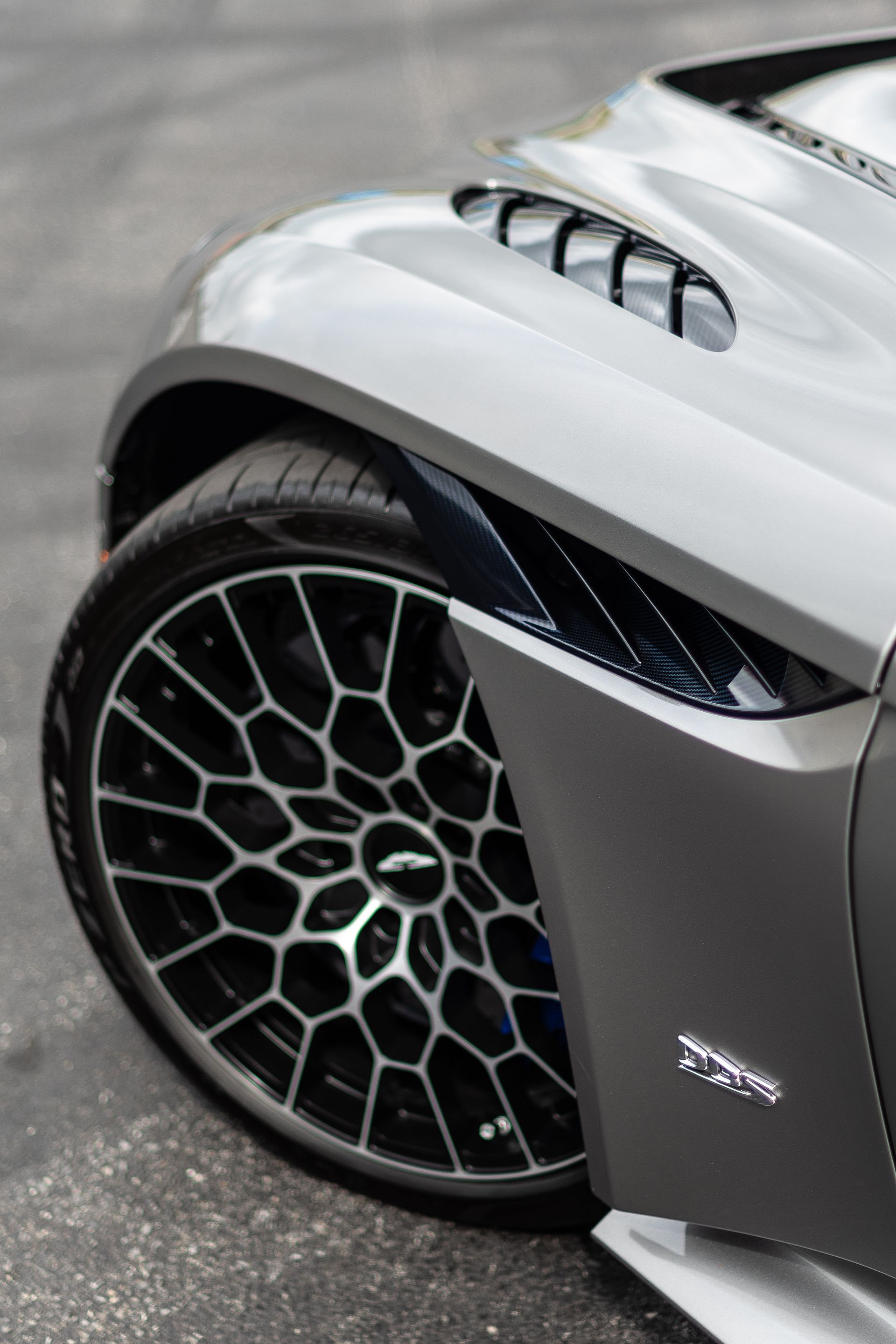 A close up of a car wheel on a road.