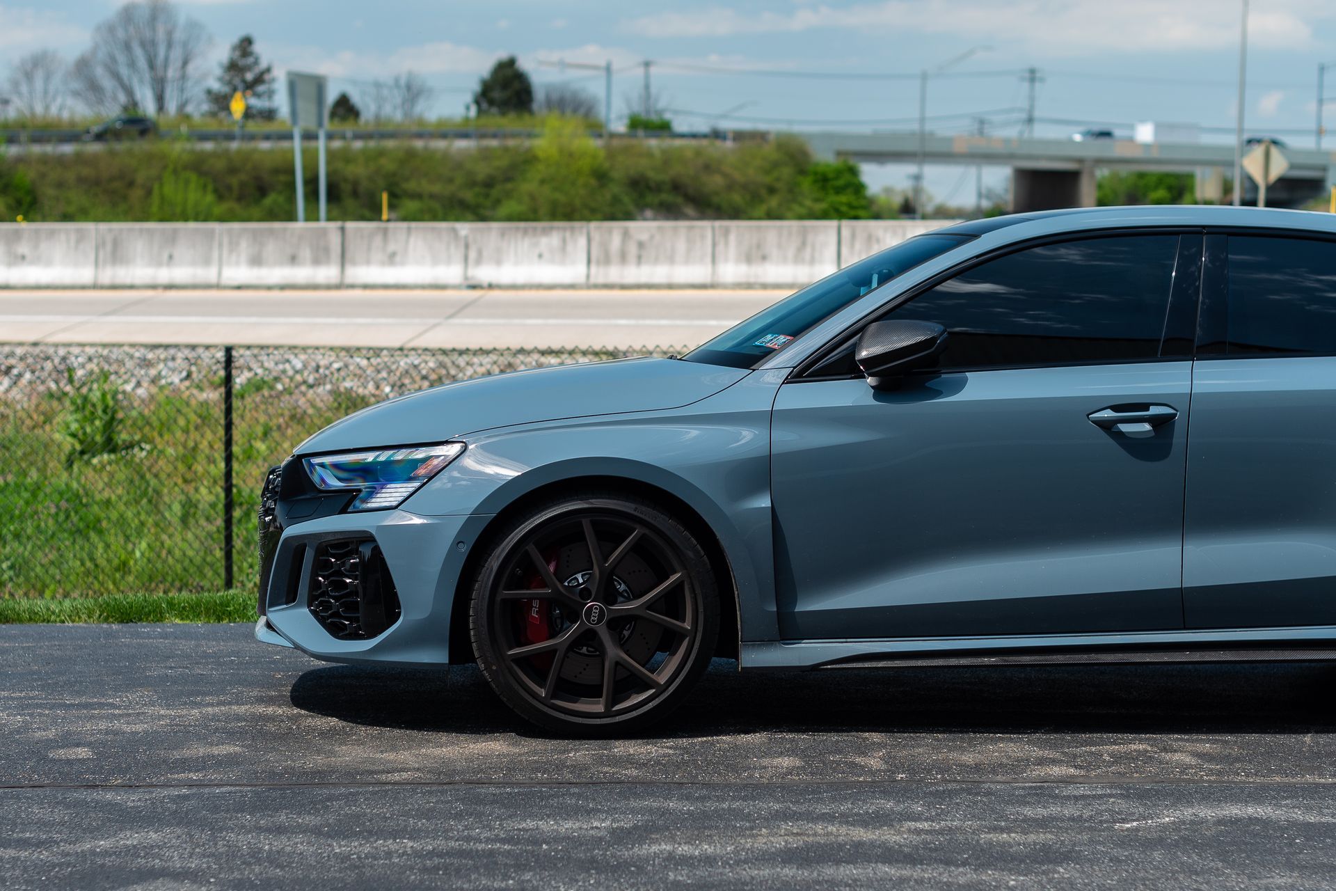 A grey audi rs 3 is parked on the side of the road.