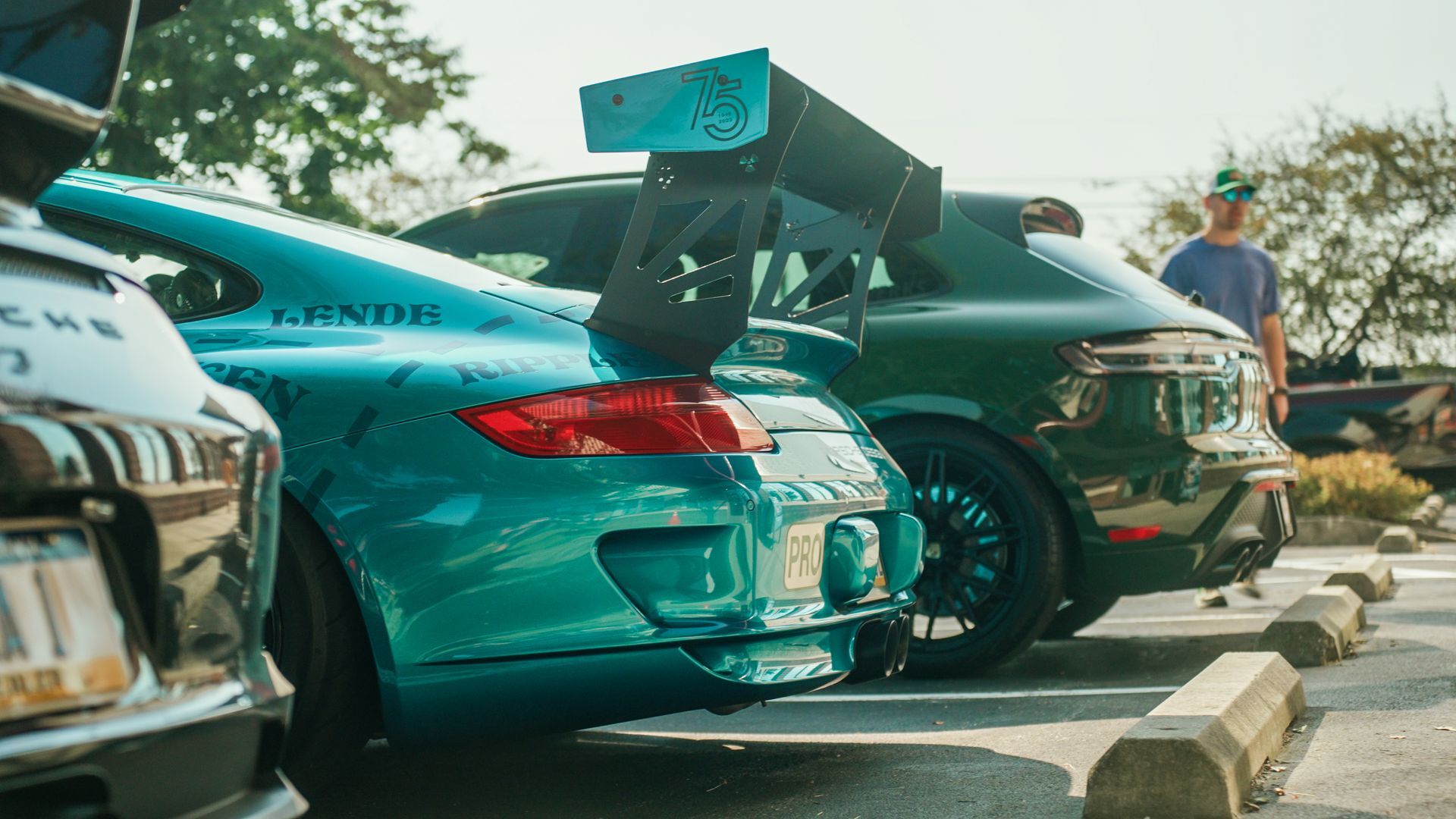 A row of cars are parked in a parking lot.