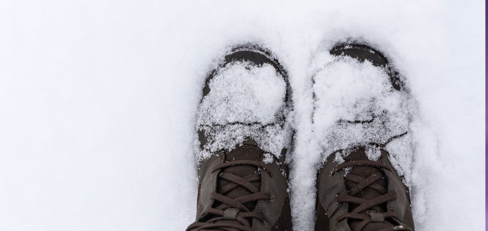 A POV photo looking down at snow covered boots, against a snowy background, taken from one of our ads for Minnesota's Department of Commerce..