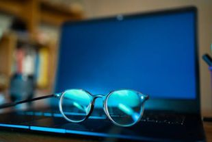 A pair of glasses is sitting on top of a laptop computer.