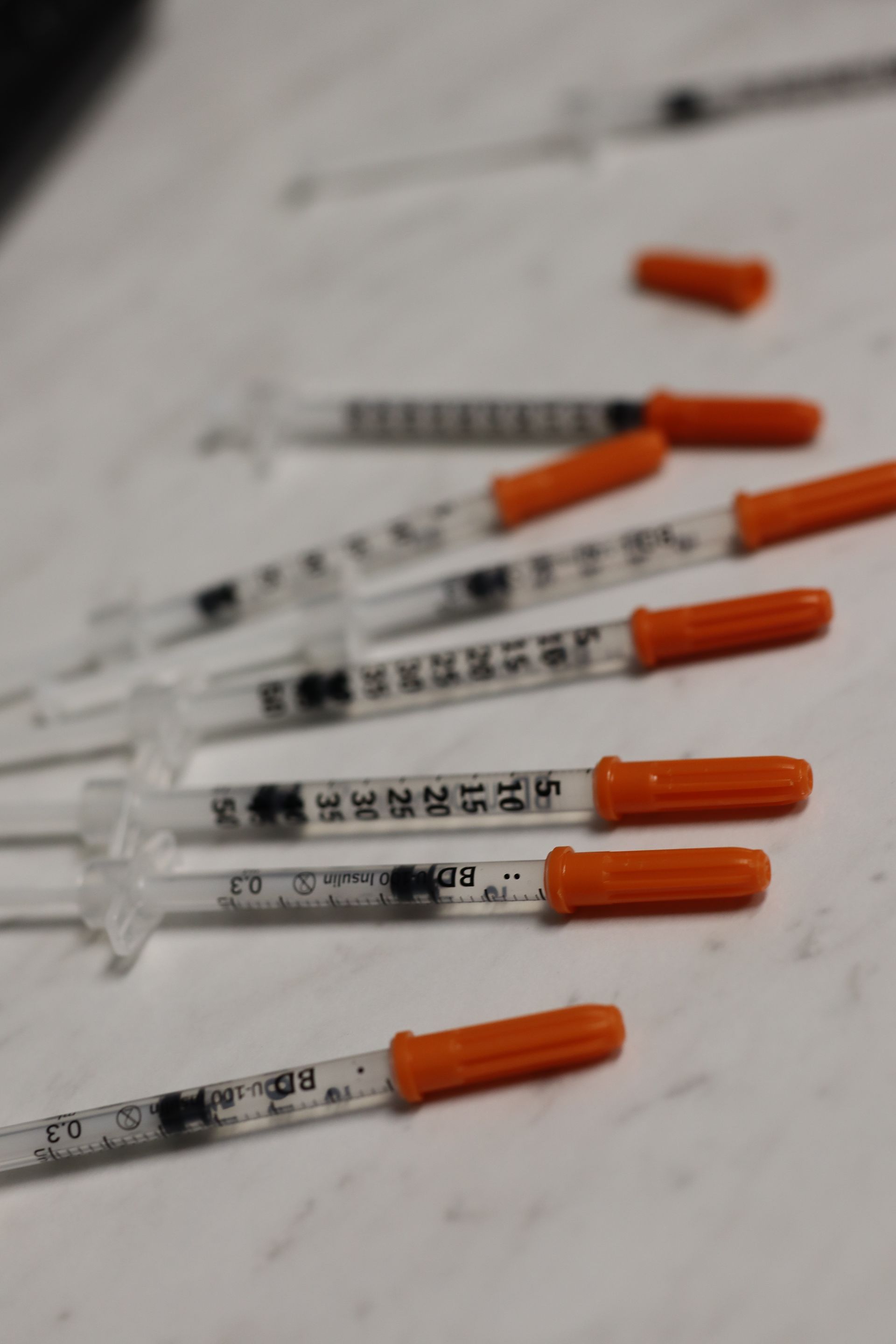 Several Botox needles neatly arranged on a sterile table, ready for use in cosmetic treatments
