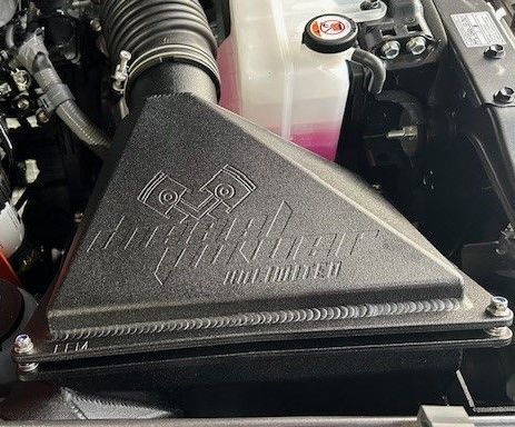 A close up of a DPU/FFM air filter in the engine of a car.