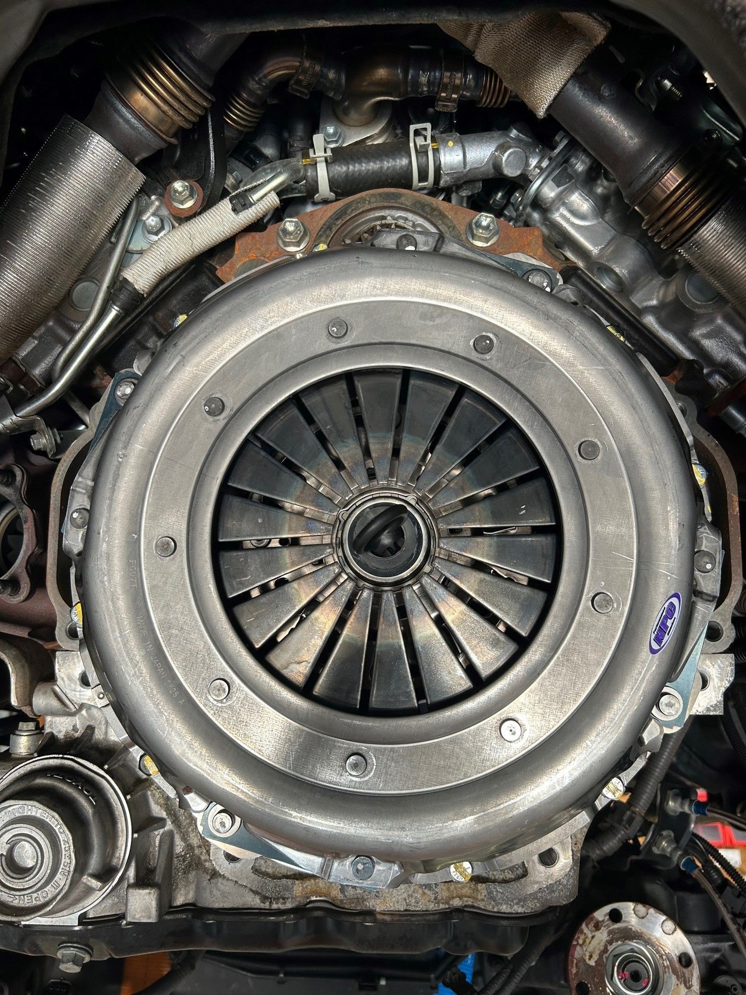 A close up of an NPC clutch cover on a car engine.