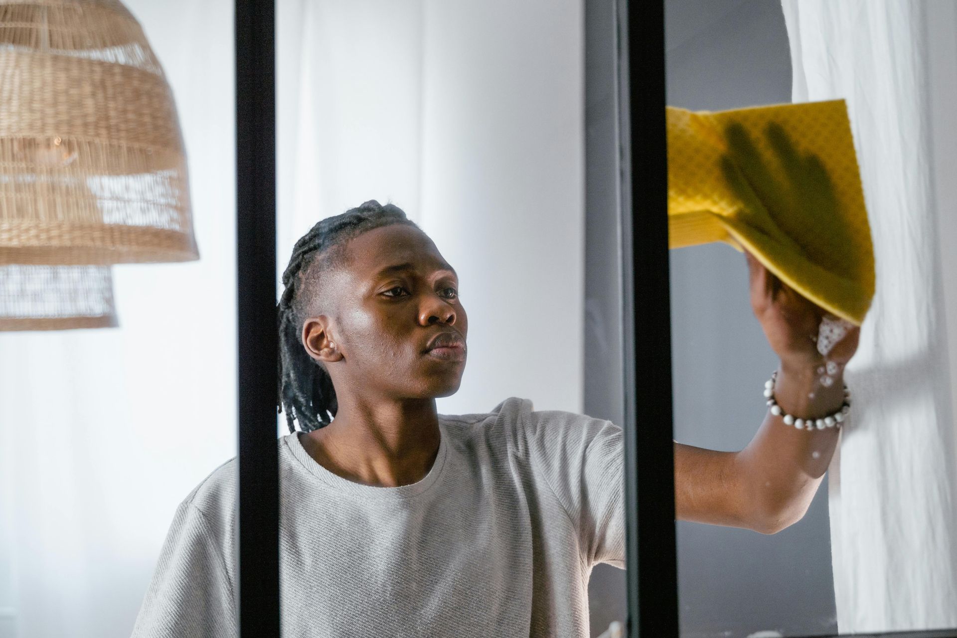 A man is cleaning a window with a yellow cloth.