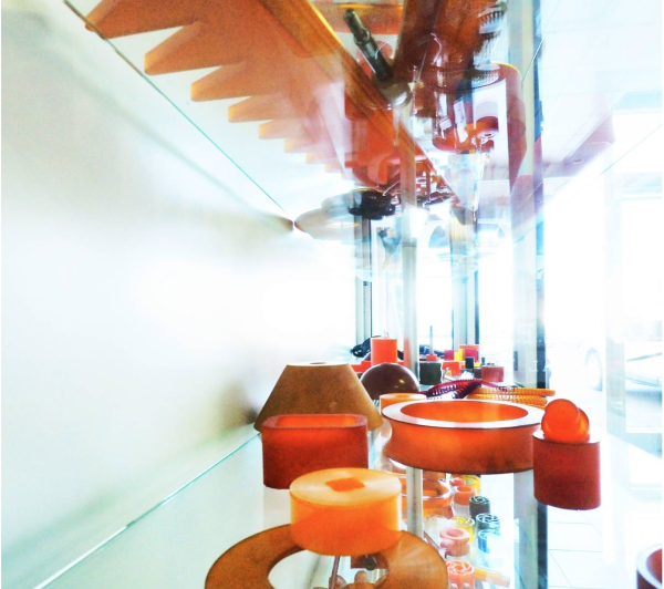 Un mucchio di candele arancioni sono su uno scaffale di vetro