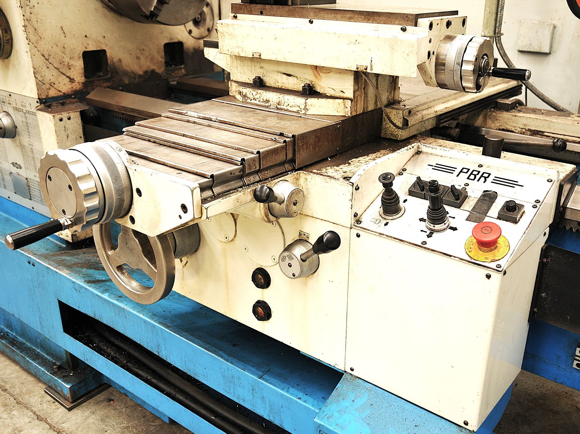 Un tornio è appoggiato su un tavolo blu in una fabbrica.