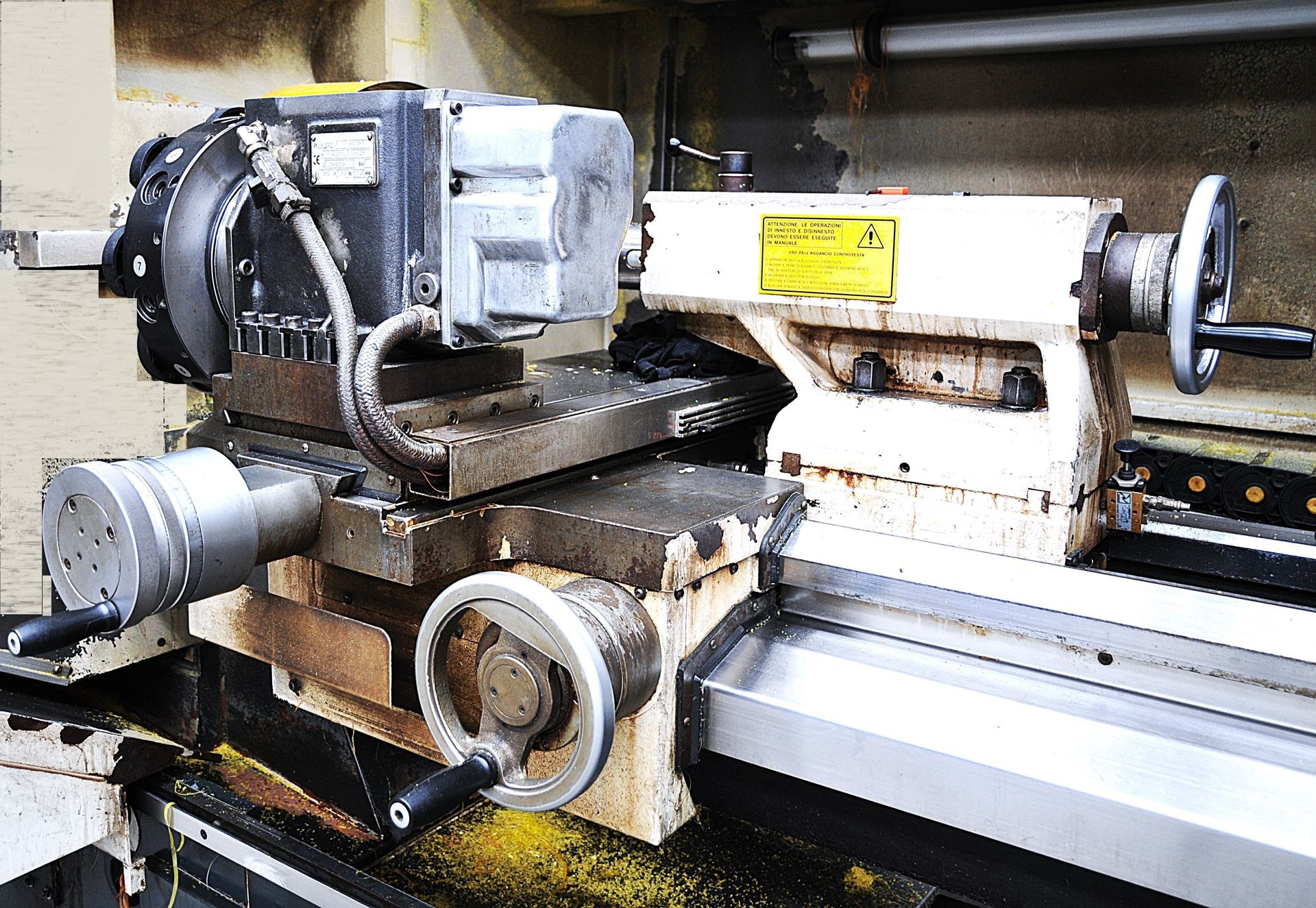 Un tornio con un motore collegato è appoggiato su un tavolo.