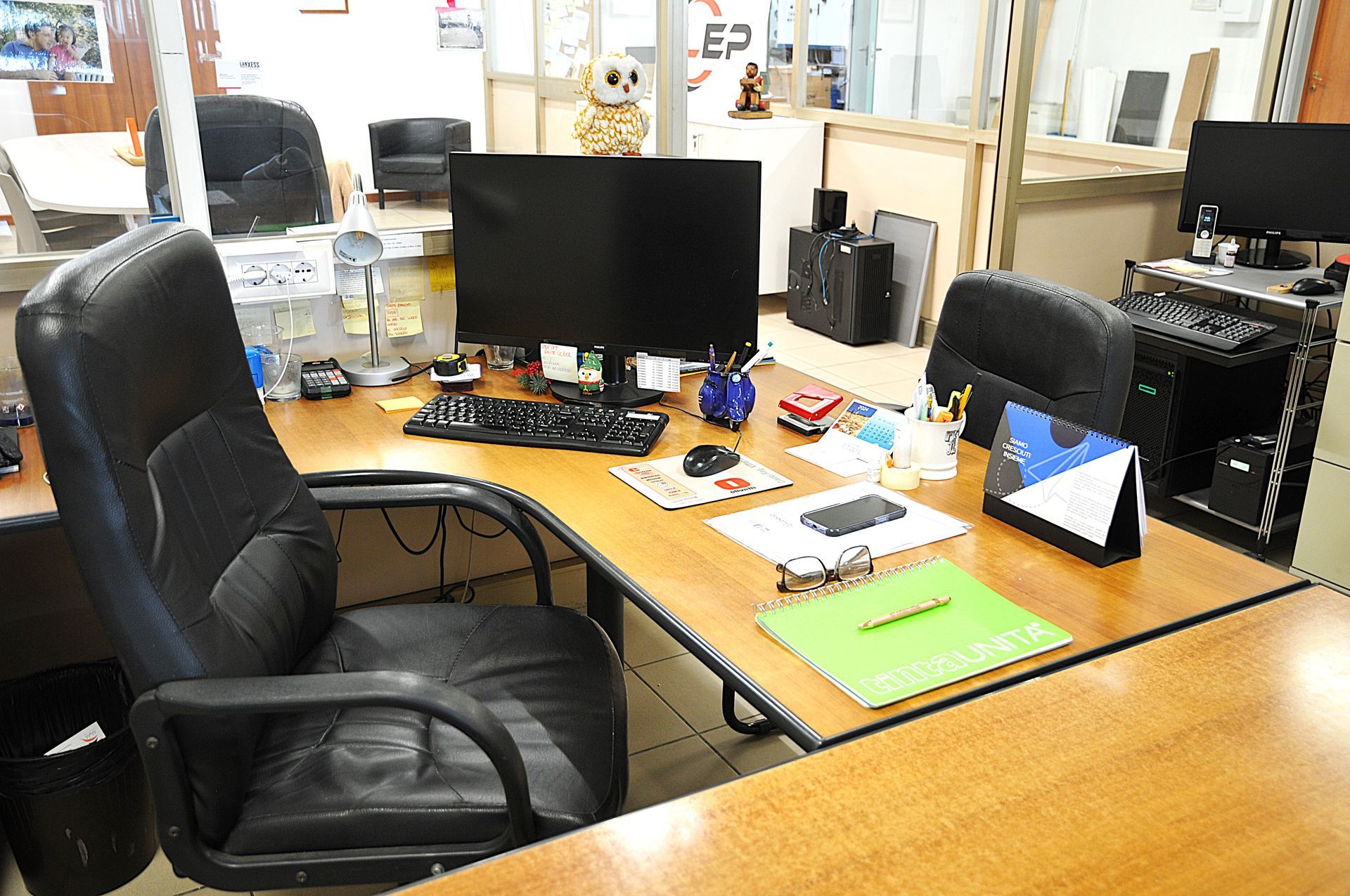 Una scrivania con due monitor per computer e un calendario.