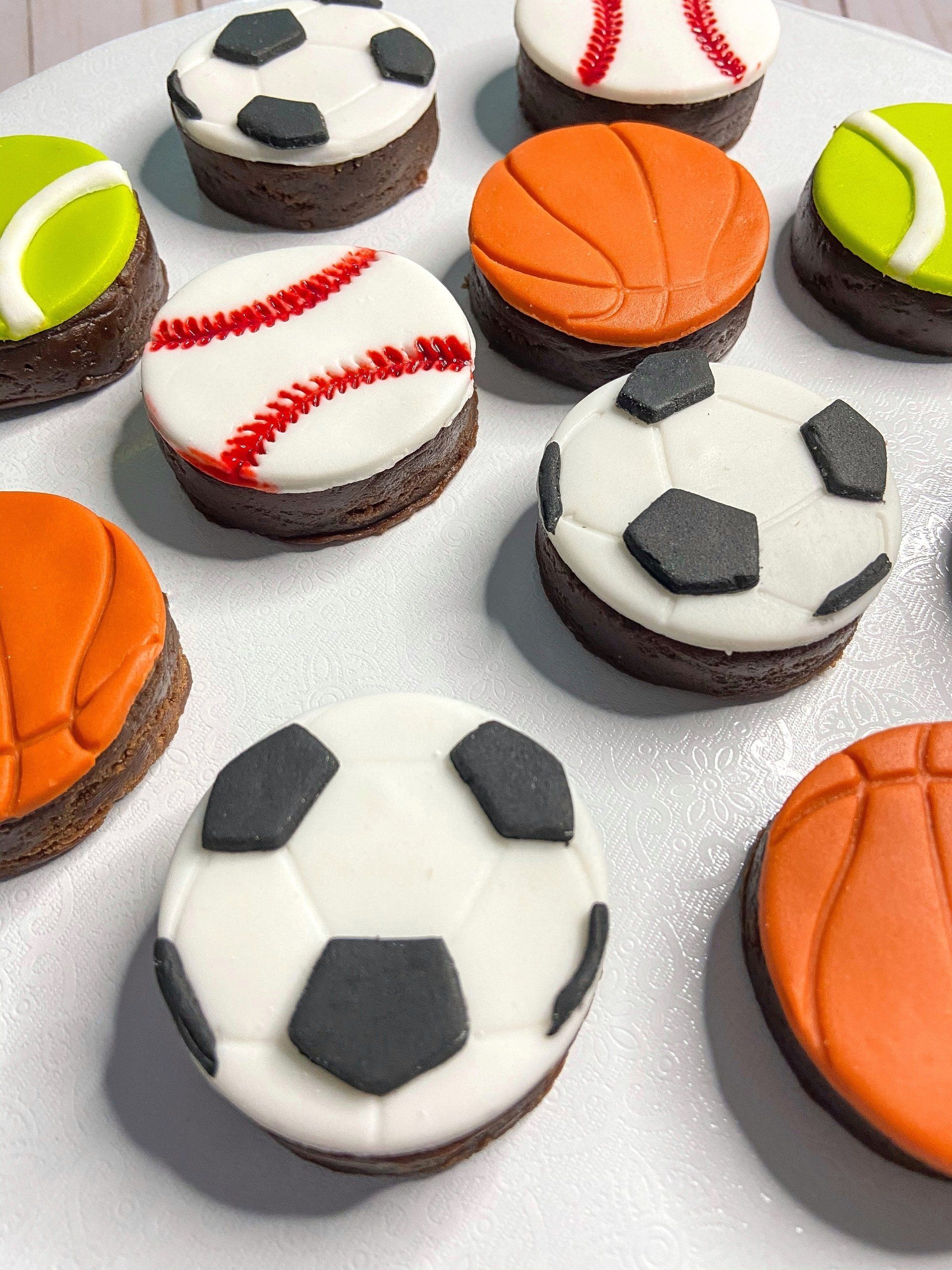 A bunch of cookies decorated to look like sports balls