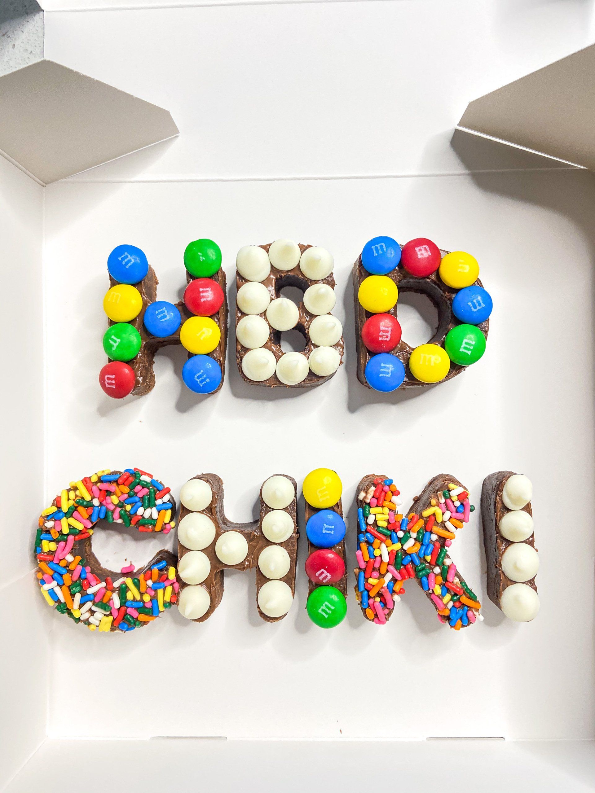 The word happy birthday is made out of chocolate and sprinkles