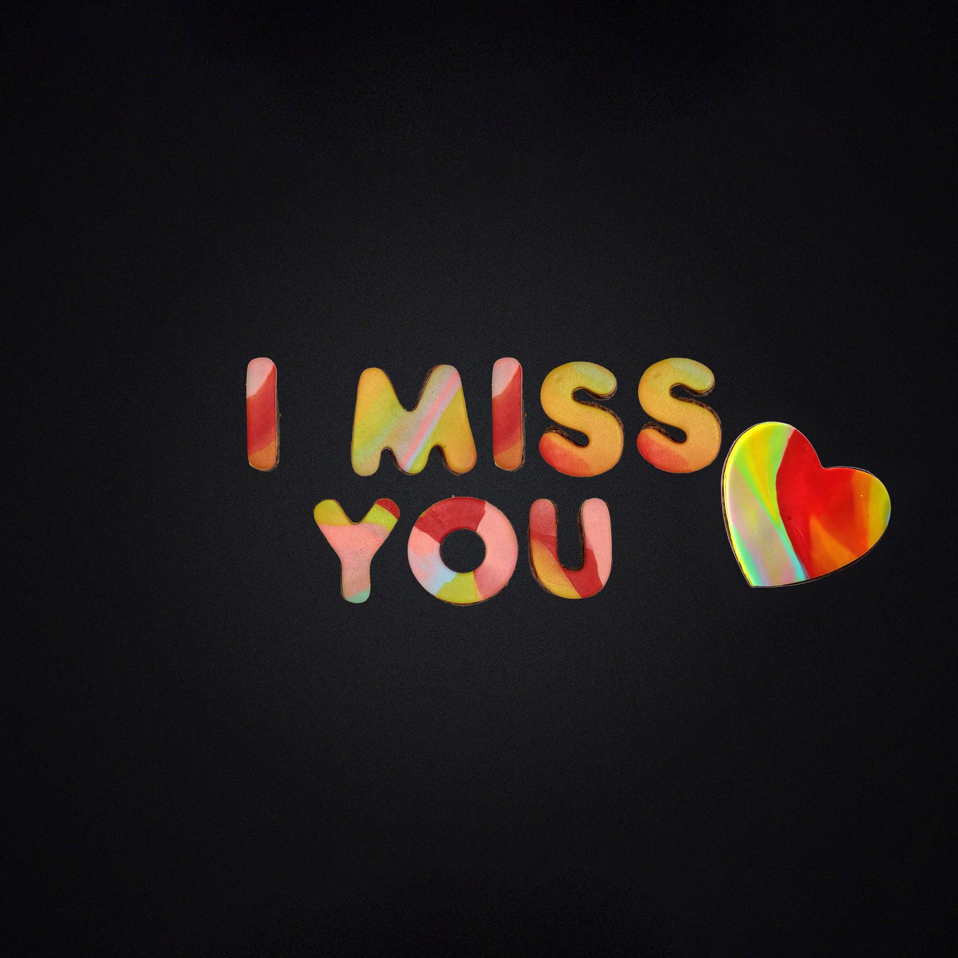 A black background with the words i miss you and a heart