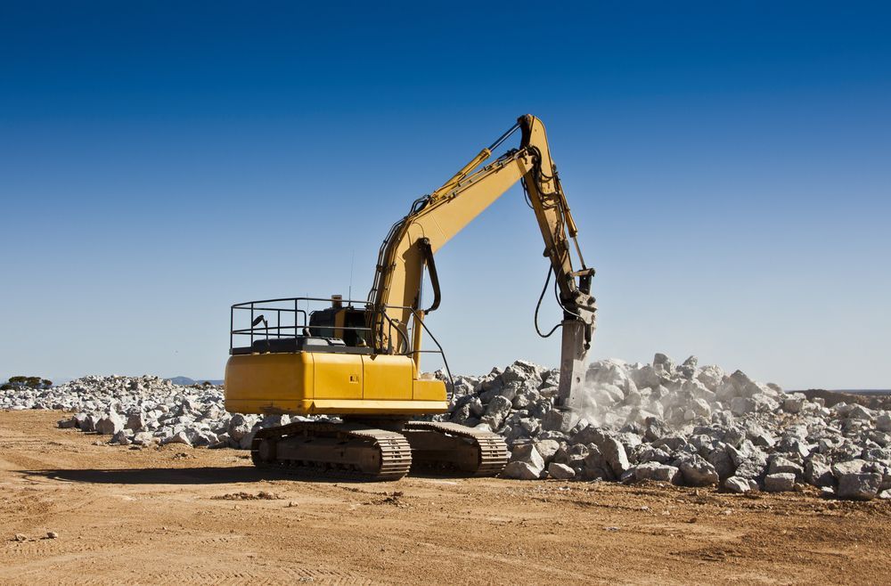 Yellow Excavator Breaking Rocks on a Construction Site — Blue Diesel & Equipment In Speewah, QLD
