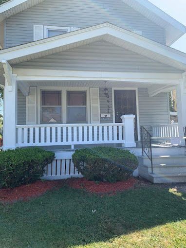 A white house with a porch and stairs
