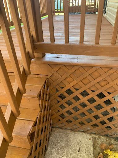A wooden deck with stairs and a lattice fence