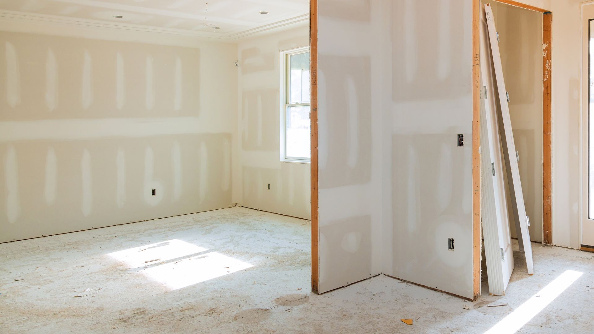 An empty room with drywall on the walls and a window