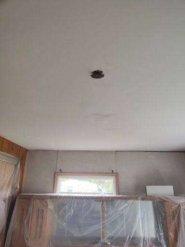 A room with a ceiling that is covered in plastic and a window.