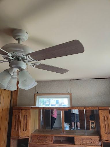 A ceiling fan is hanging from the ceiling of a room.