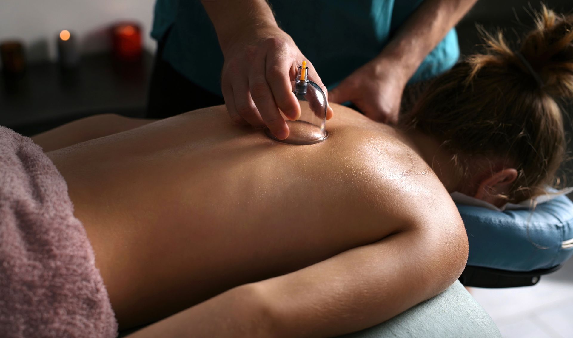 Person receiving cupping therapy on their back, in a spa-like setting. Person receiving cupping therapy on their back, in a spa-like setting.