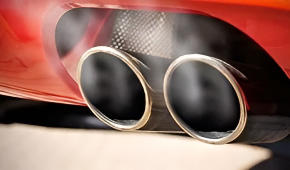 A Close Up of a Car Exhaust Pipe With Smoke Coming Out of It — Sprint Mufflers, Exhausts & Mechanical Repairs in Stuart, NT