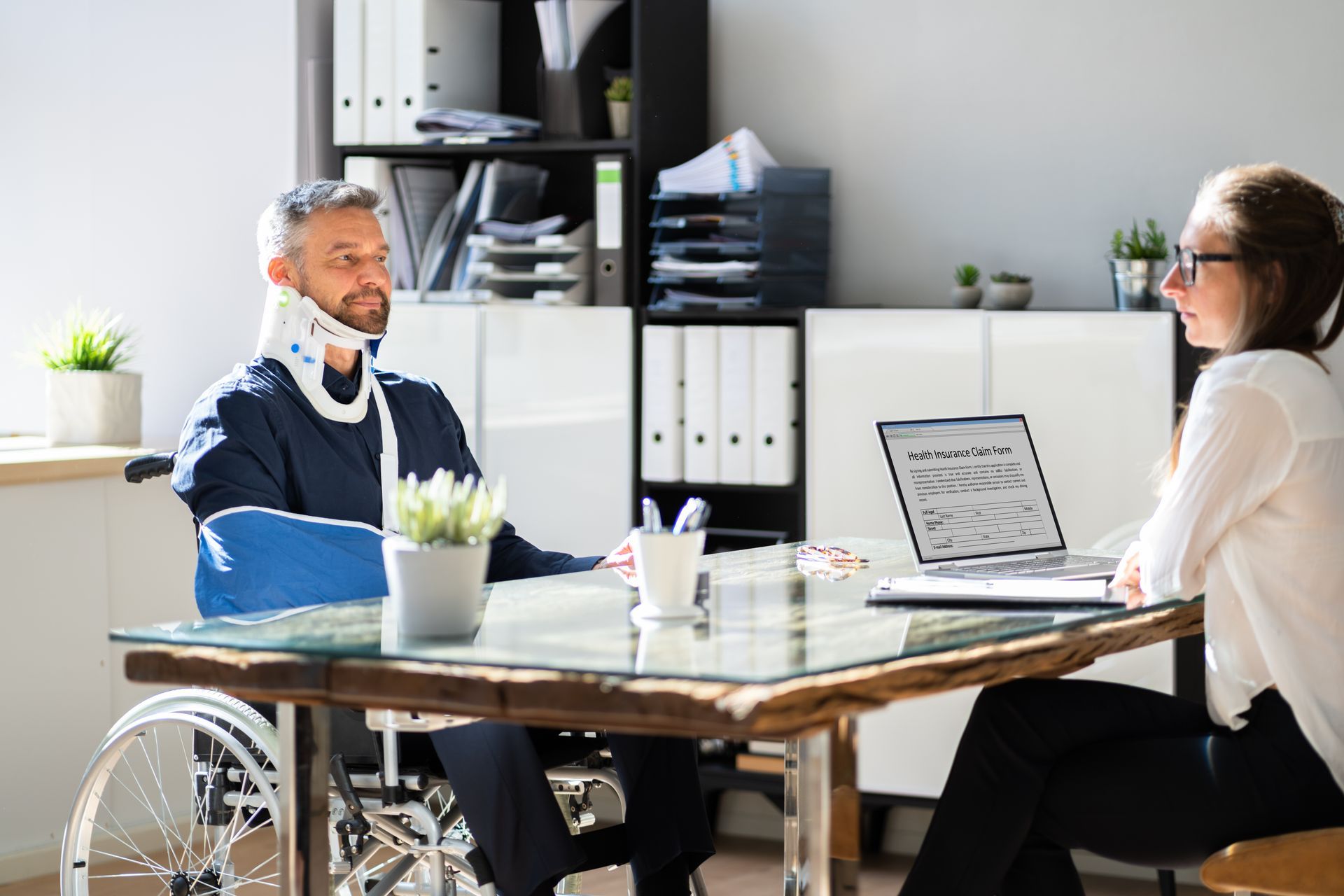 A man in a wheelchair is sitting at a table with a woman.