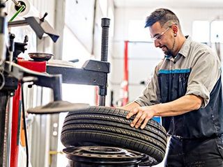 Car Repair — Worker Repairing Tire in Lino Lakes, MN