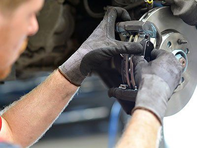 Auto Repair — Mechanic Repairs Brakes From Vehicle in Lino Lakes, MN