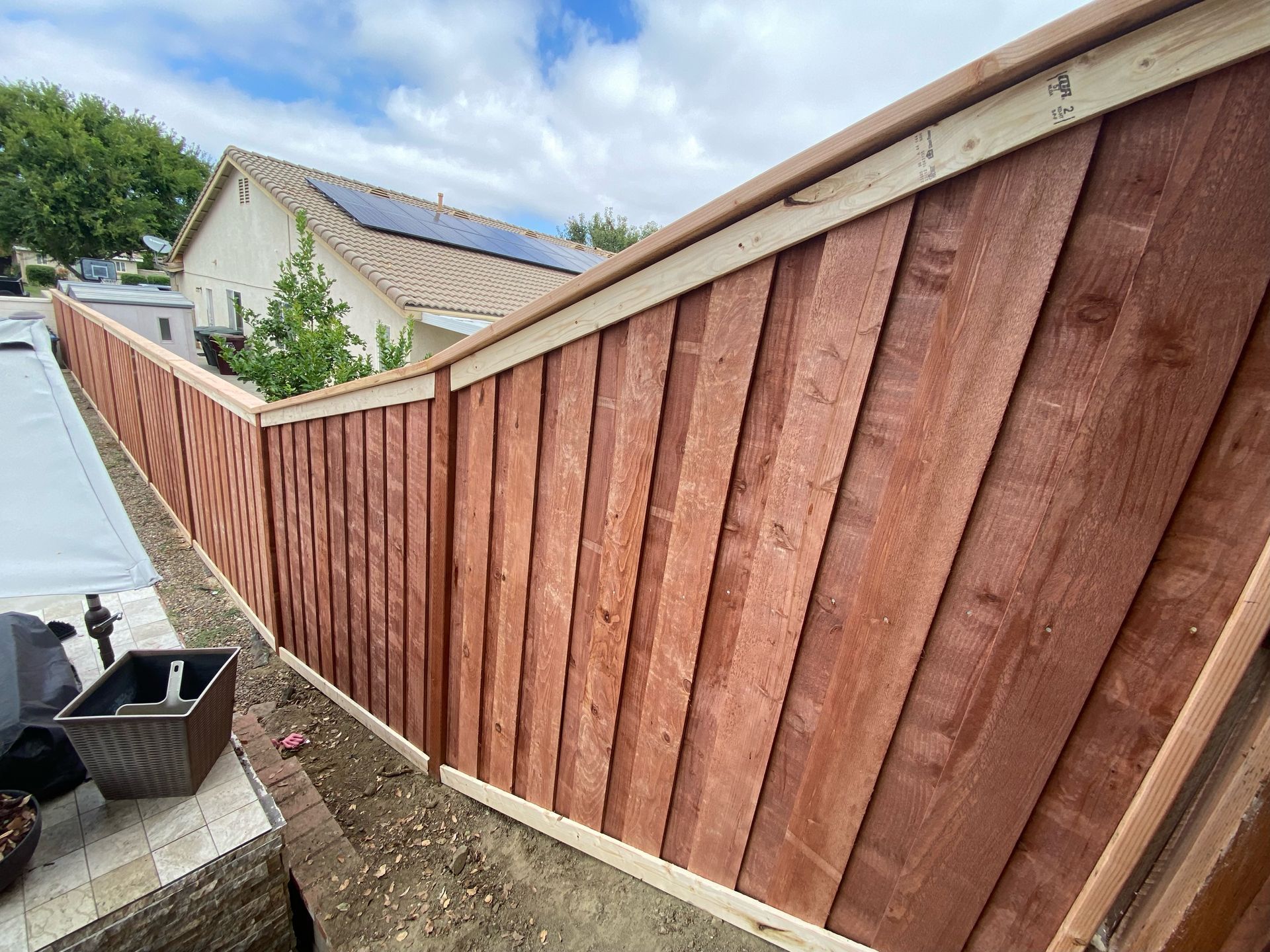 A wooden fence is being built in front of a house.