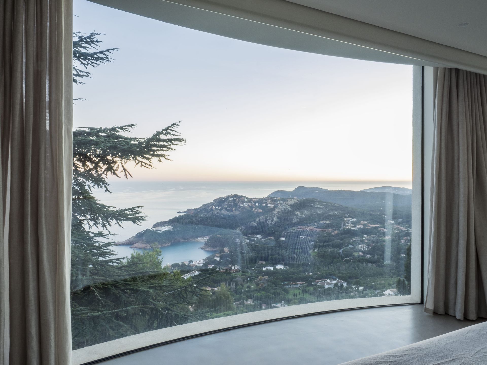  Panoramic curved windows by OTIIMA, offering stunning views of the surrounding landscape. 