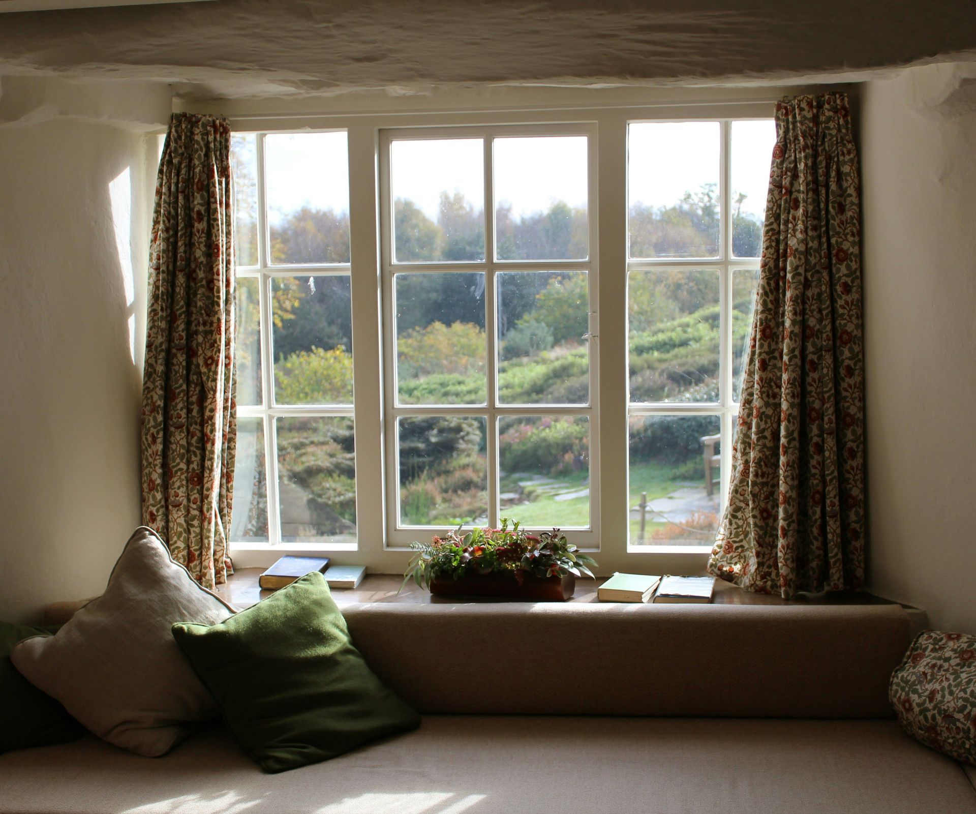 Traditional white window in a home setting, featuring white and beige tones, with a view of the natural landscape outside