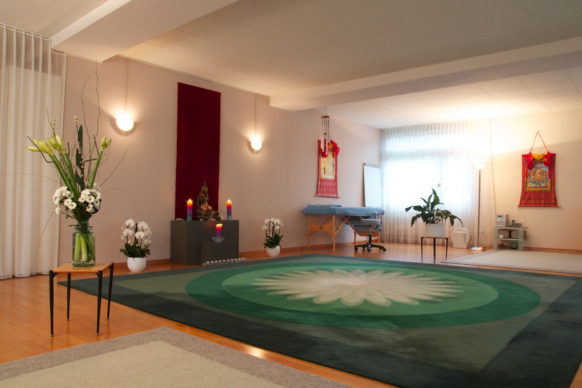 Ein Zimmer mit einem grünen Teppich und einem Tisch mit Blumen darauf