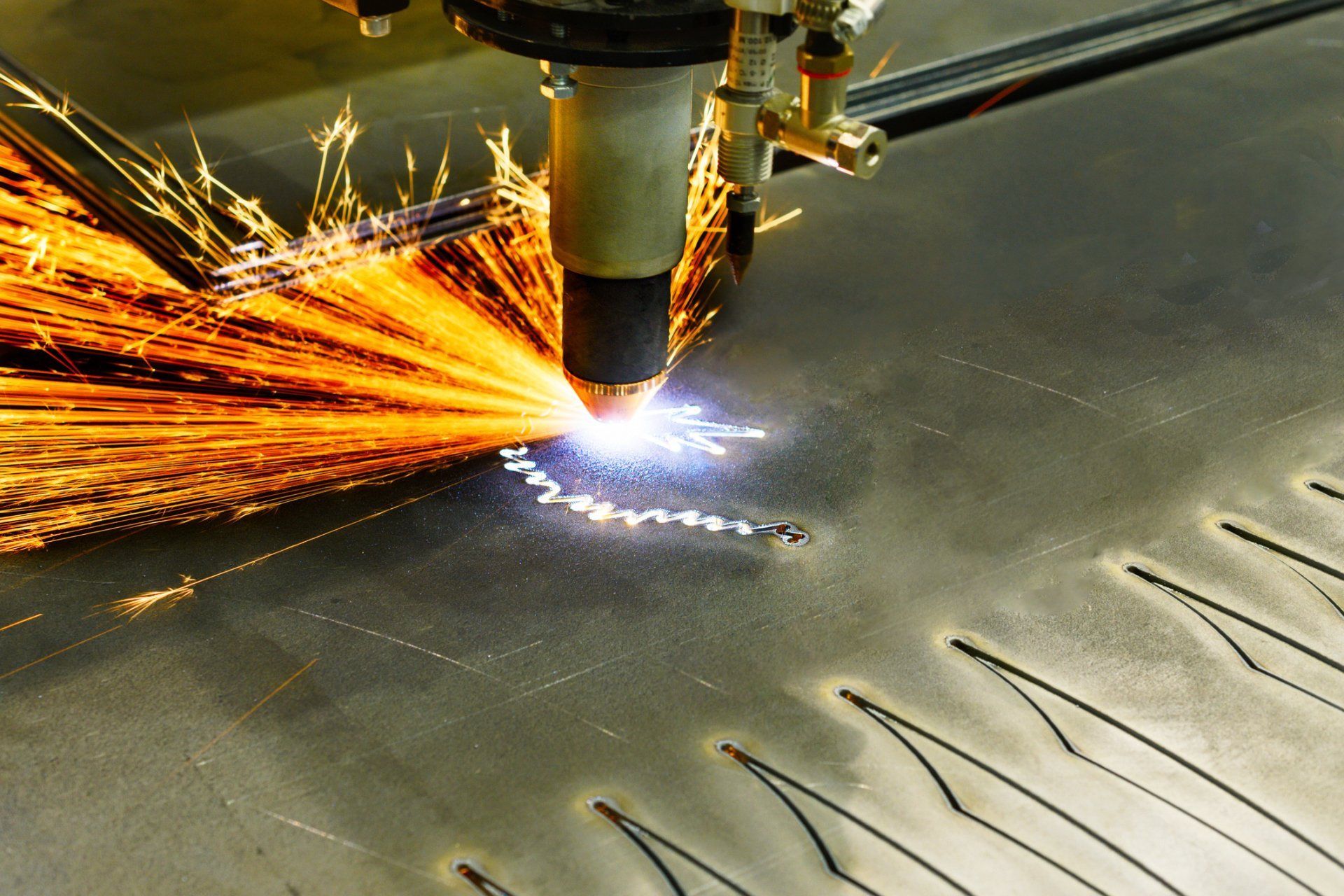 A man wearing a welding helmet meticulously welds metal pieces together on a table.