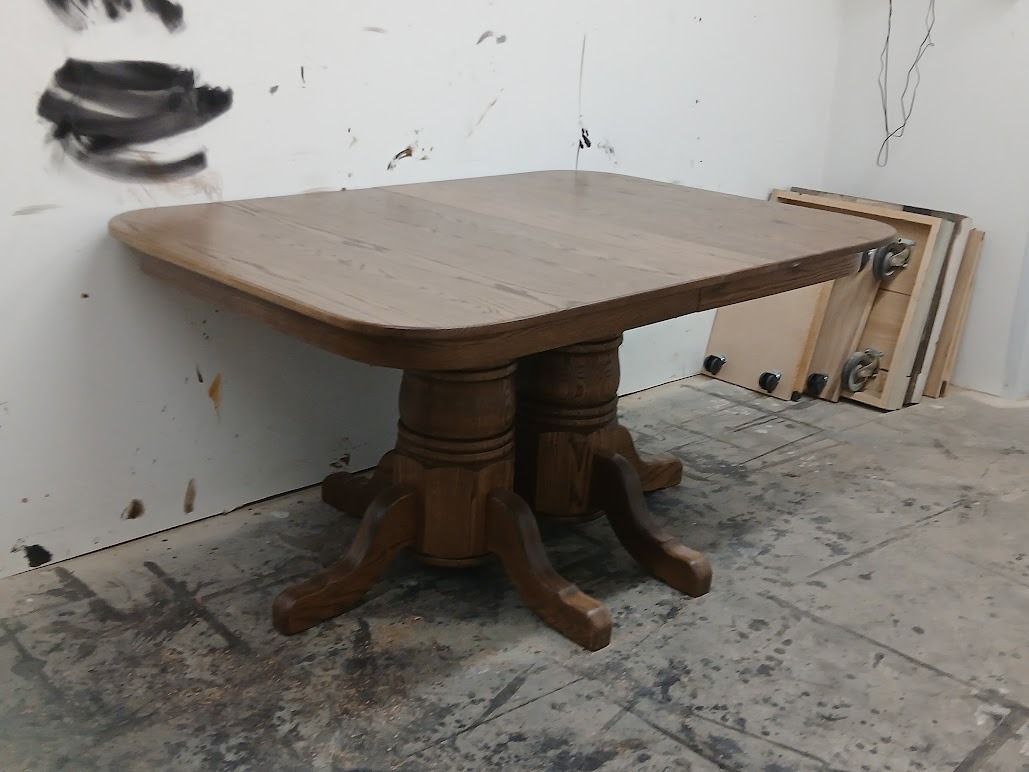 Small round wooden table on a concrete floor against a wall in a sparse, worn room