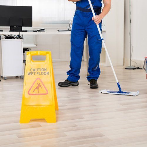 person mopping office floor in commercial building