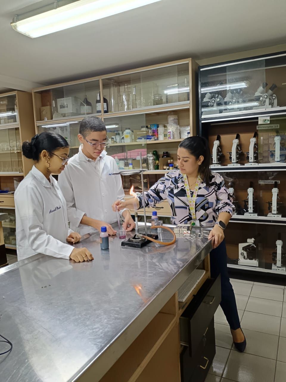 Un grupo de personas están de pie alrededor de una mesa en un laboratorio.