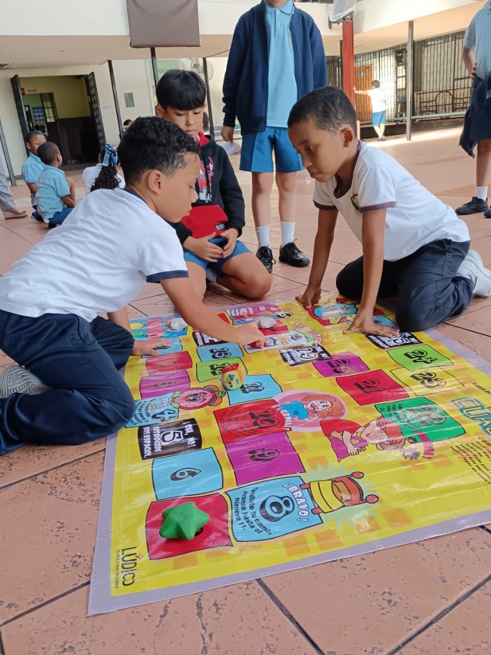 Un grupo de niños pequeños están jugando a un juego de serpientes y escaleras.