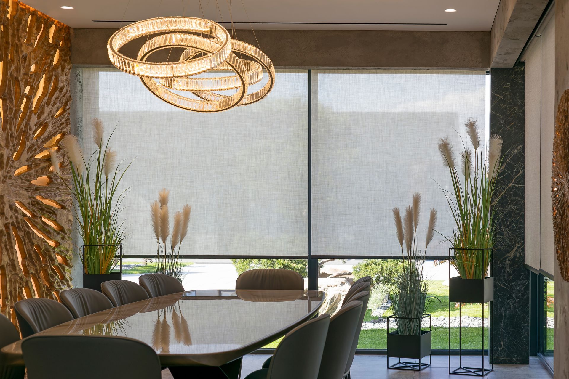 Modern conference room with long table, dark chairs, woven pendant lights, and large window shades