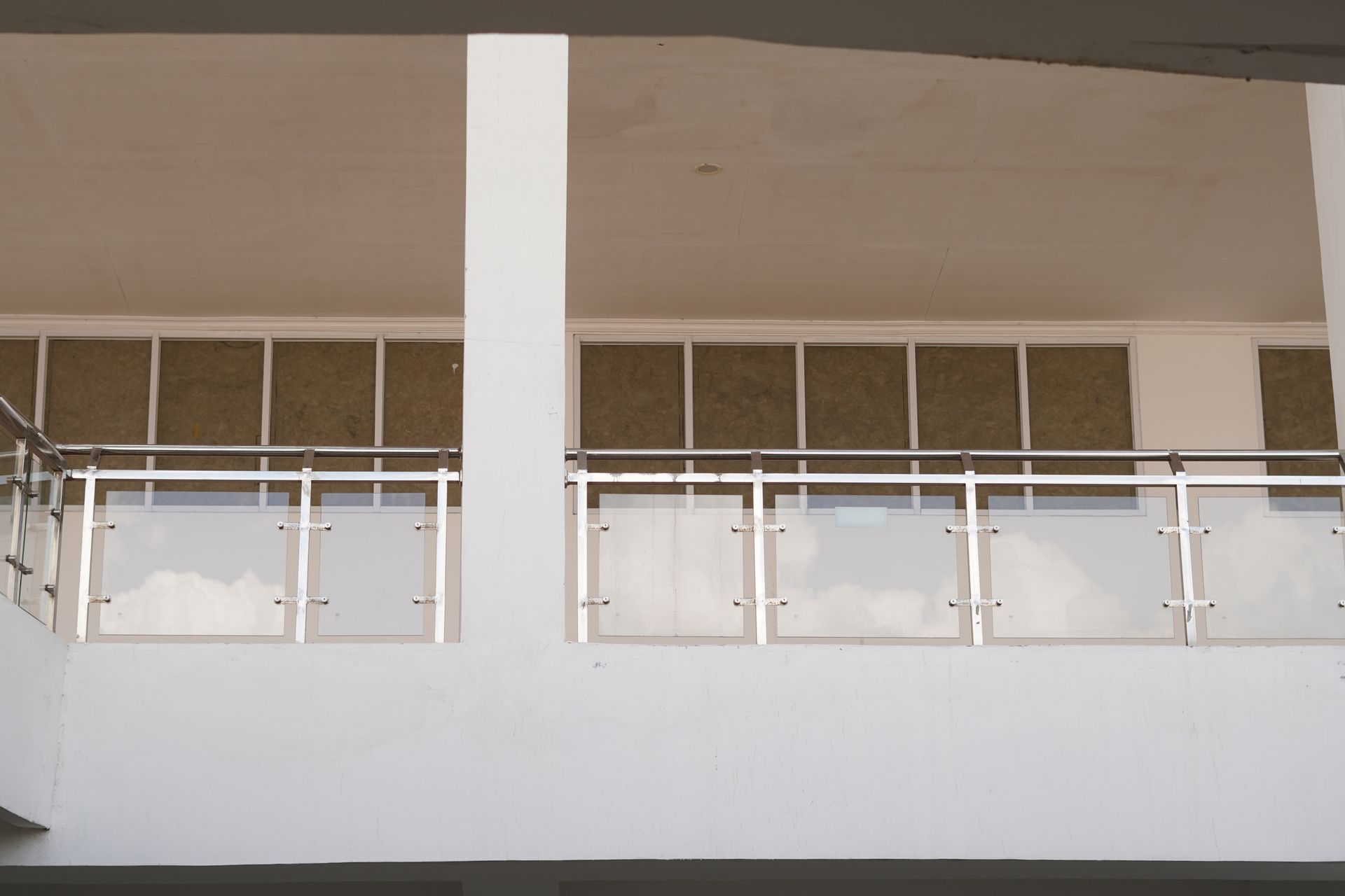 White balcony railing and columns on a beige building exterior