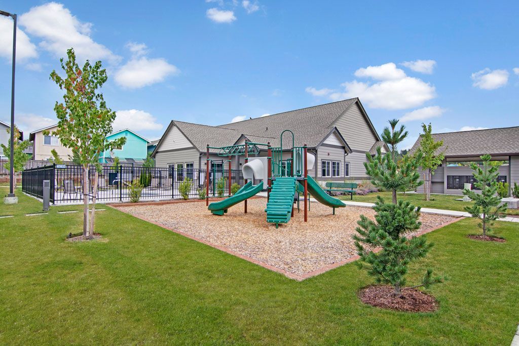 a playground in a park with a house in the background .