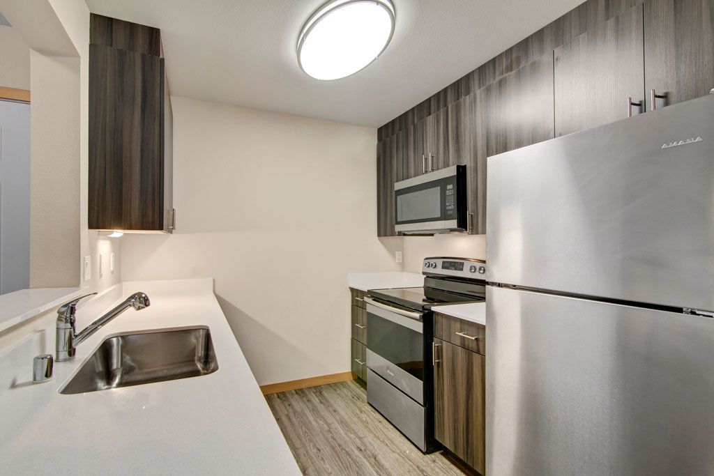 a kitchen with stainless steel appliances and wooden cabinets .