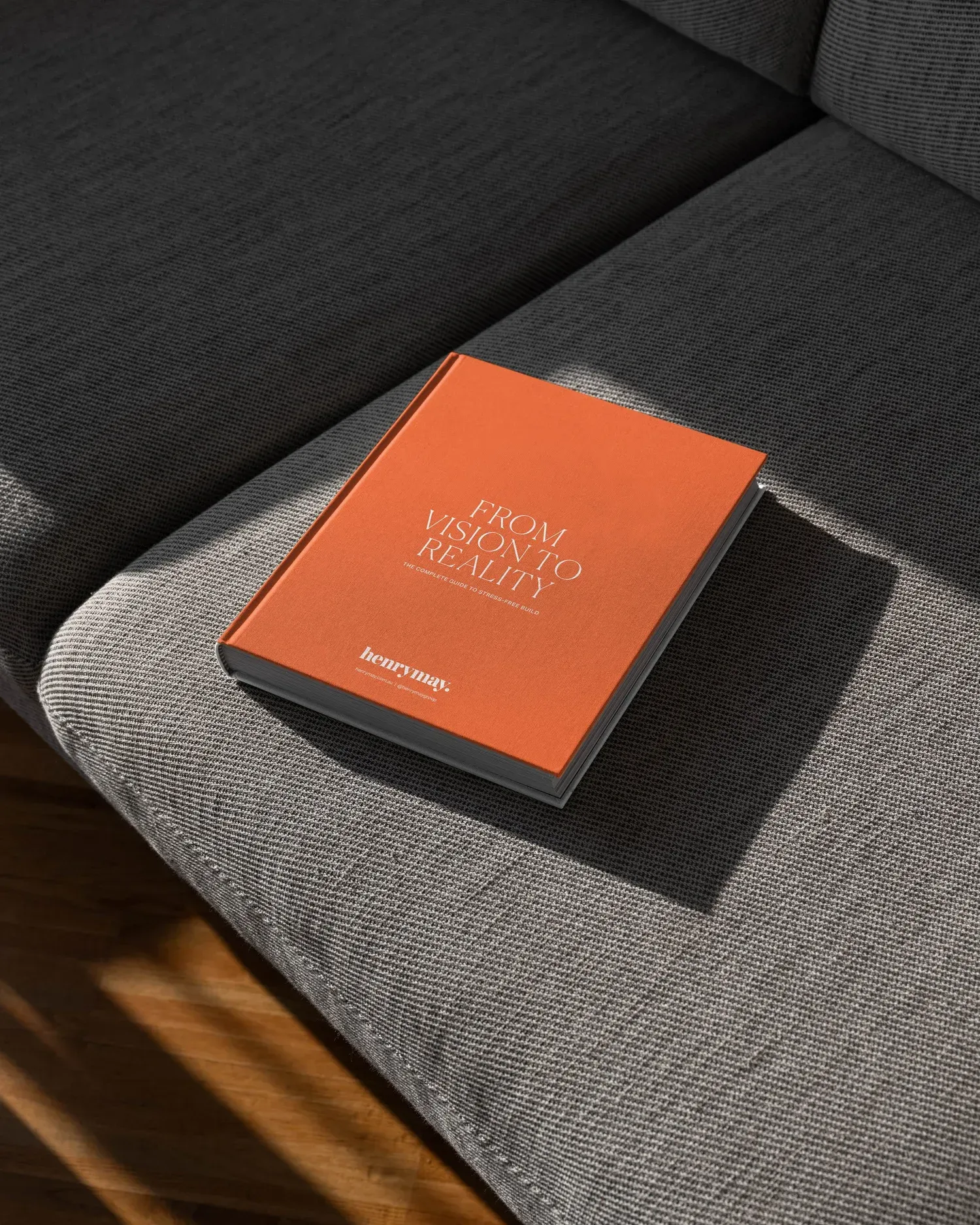 Orange book on a gray couch cushion in sunlight