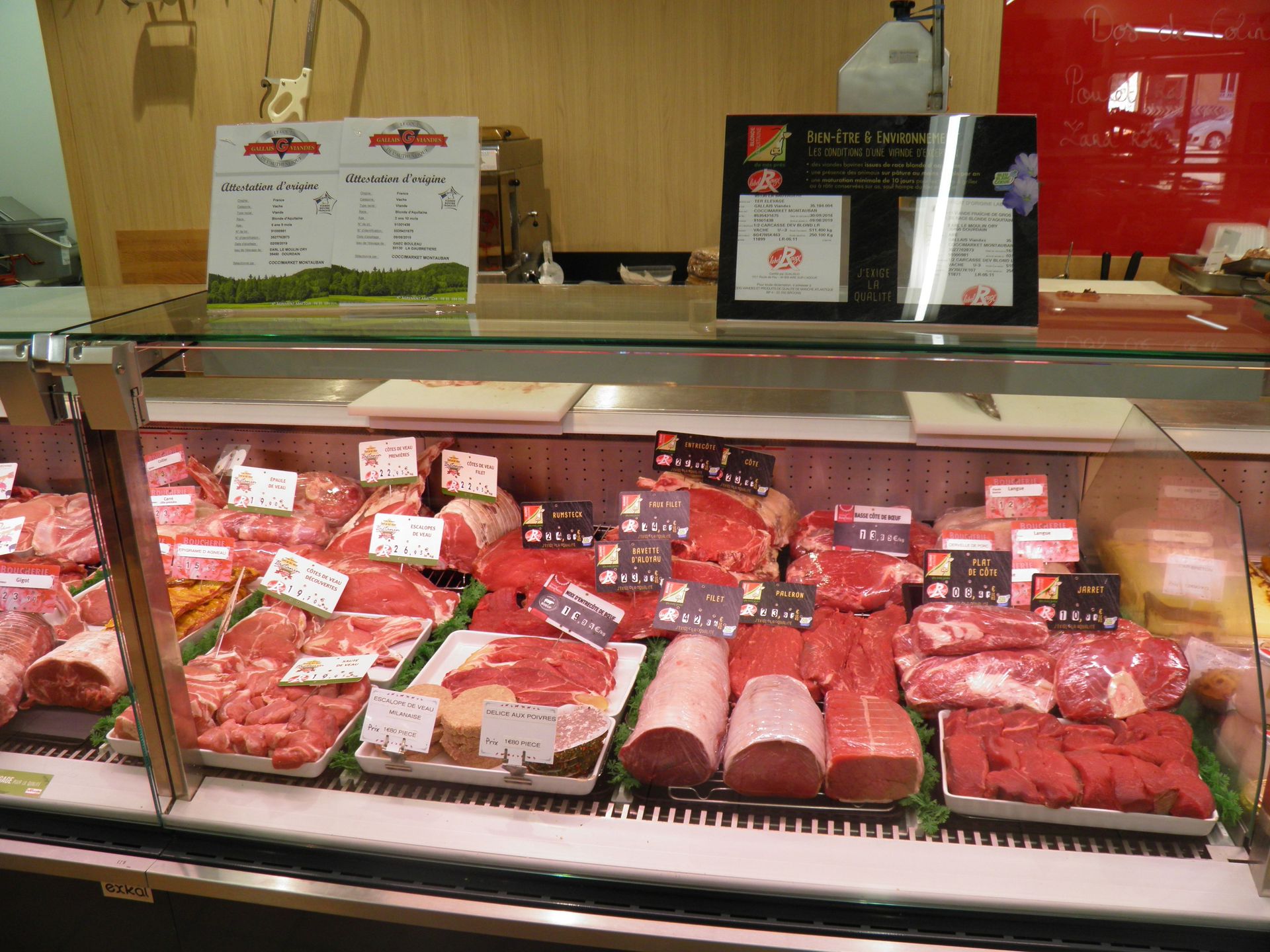 Une vitrine de boucher remplie de viande et de légumes.