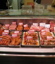 Une vitrine remplie d'une variété de viandes et de légumes.